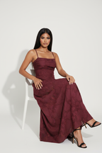 Modelo sentada con vestido largo jacquard burdeos