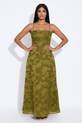 Modelo manos en cadera con vestido floral verde oliva