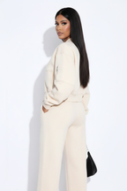 Modelo conjunto oversize crema - mirando por encima del hombro